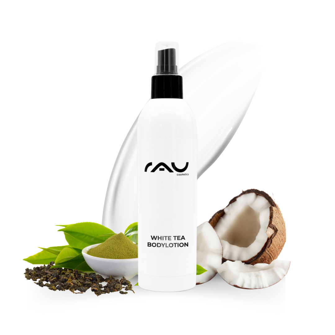 Flacon de White Tea Bodylotion avec logo RAU, entouré de feuilles de thé vert, de poudre verte et de noix de coco, soulignant les propriétés hydratantes et nourrissantes pour peaux sèches.