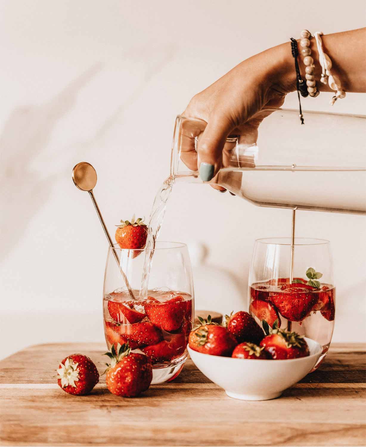 Infused Water – erfrischendes Sommergetränk mit Zitronenscheiben, Gurkenscheiben und Minzblättern in einem Glas, dekoriert mit frischen Zutaten