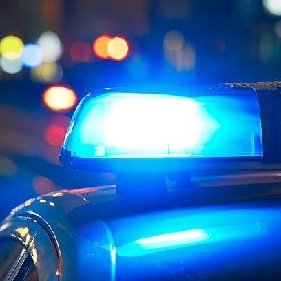 Blaulicht von einem Polizeiauto, das in der Nacht leuchtet, um auf eine Situation aufmerksam zu machen.